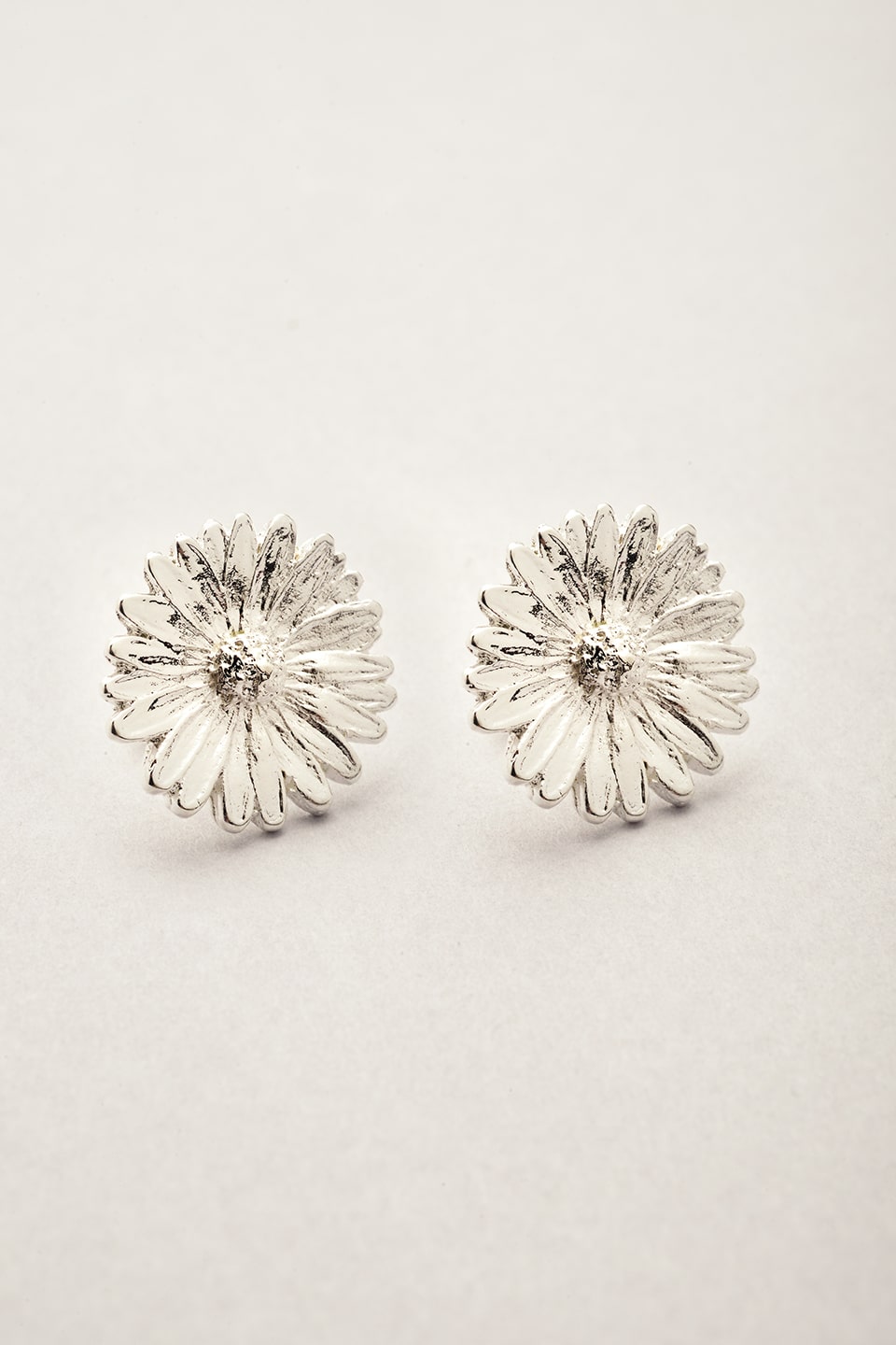 Puces d’oreilles en forme de fleur argentée. Légères, lumineuses et fabriquées en France, parfaites pour compléter vos bijoux Musardise.