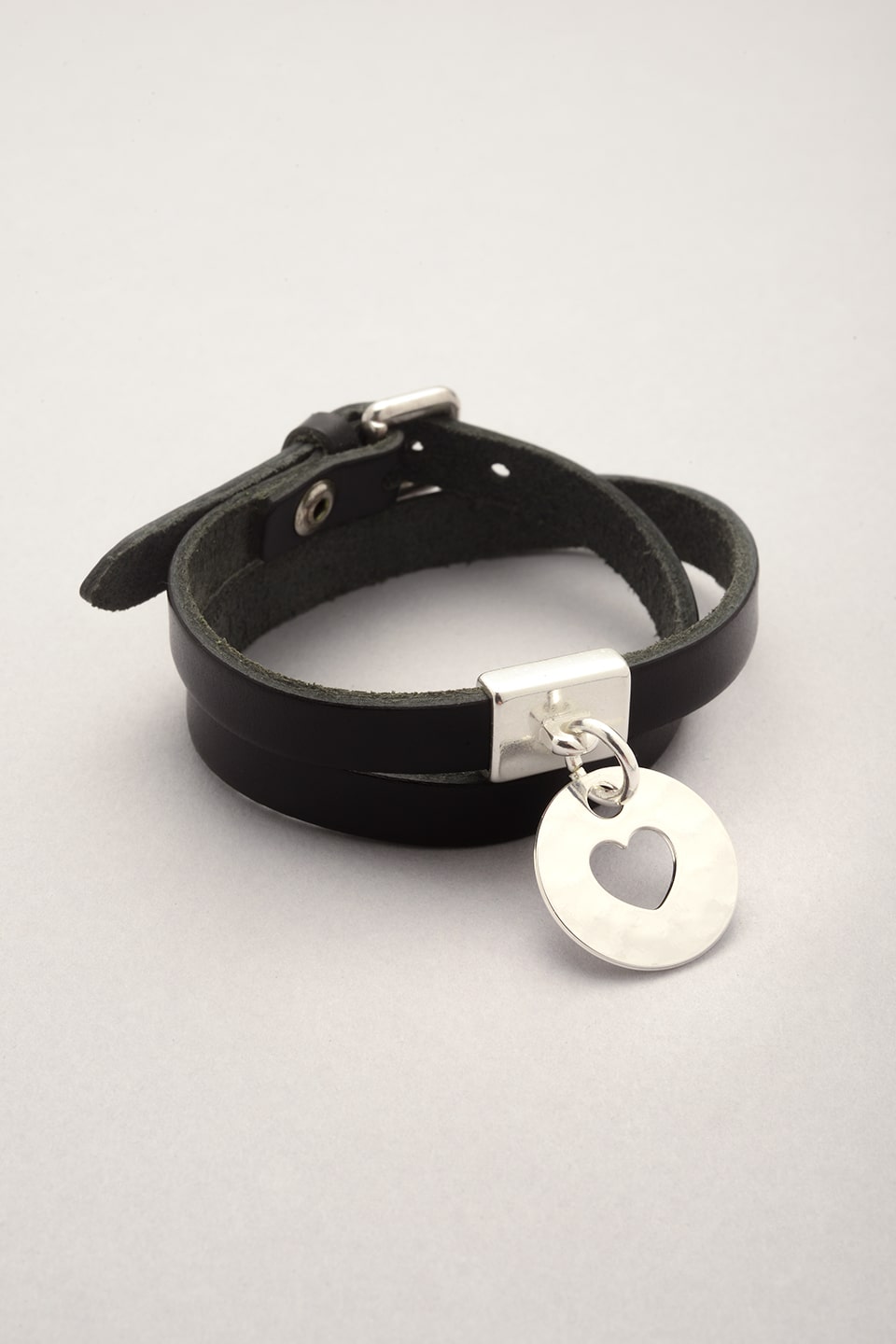 Ce bijou est composé d'un bracelet en cuir et d'une médaille ronde avec un coeur évidé argenté. Cuir véritable, bijou fantaisie pour femme. 
