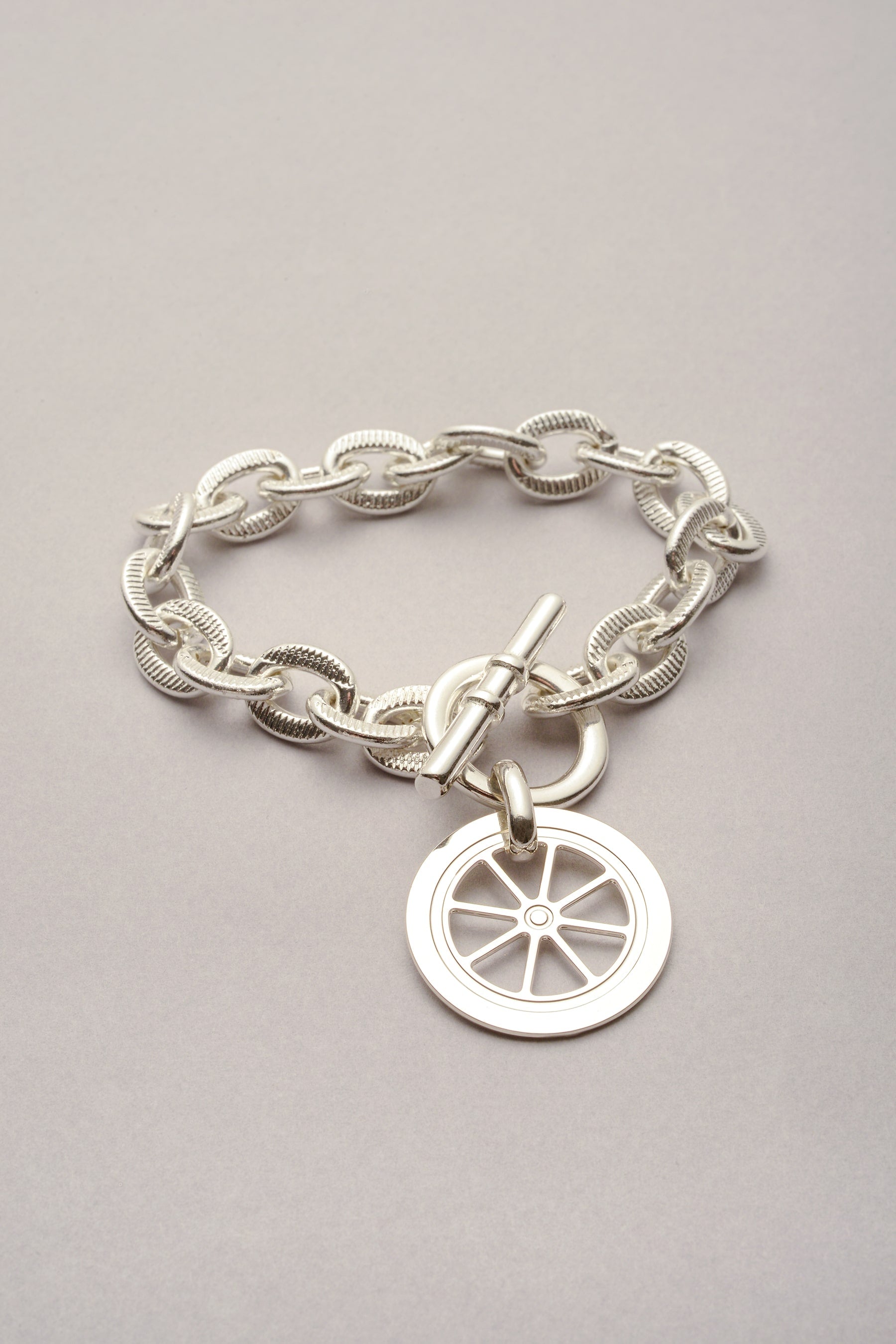Le bracelet Scarlett pendentif Roue est composé d'une chaîne argenté et d'un fermoir en T. Bijou fabriqué en France. 