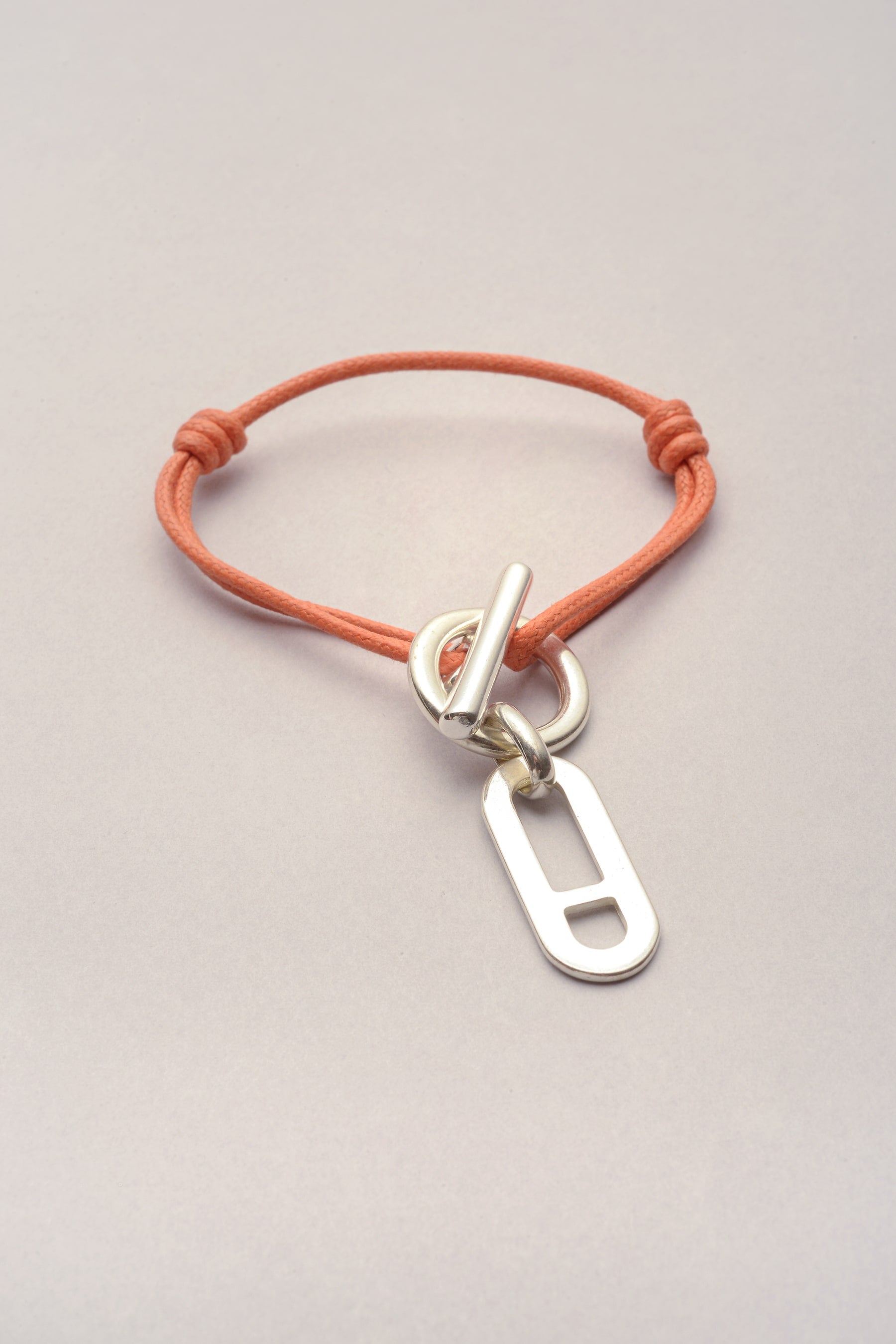 Ce bracelet attache pendentif Noe avec cordon de coton colore ajustable. Ce bijou est composé d'un fermoir en T et de deux noeuds coulissants ce qui rend pratique l'utilisation du bracelet. 