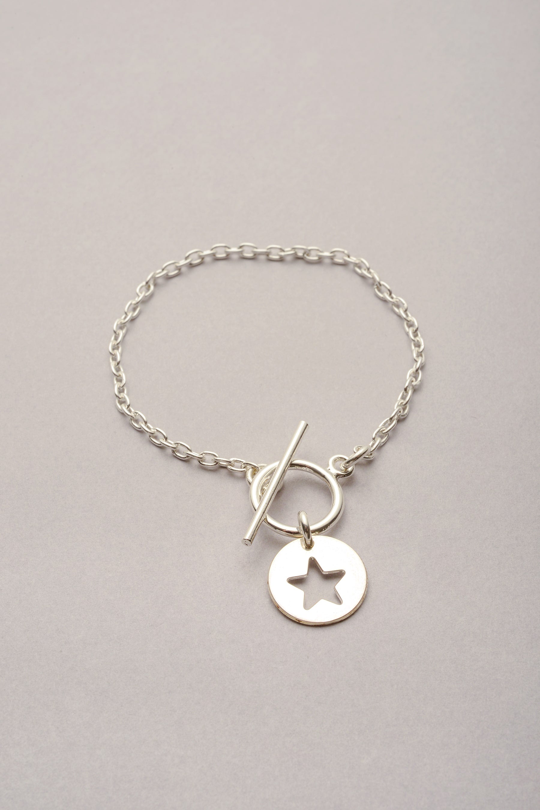 Bracelet composé d'une chaîne argentée et d'un fermoir en T. fabriqué en France, ce bracelet est orné d'une médaille étoile ajourée. Idée cadeau maman, idée cadeau enfant, idée cadeau fille. 