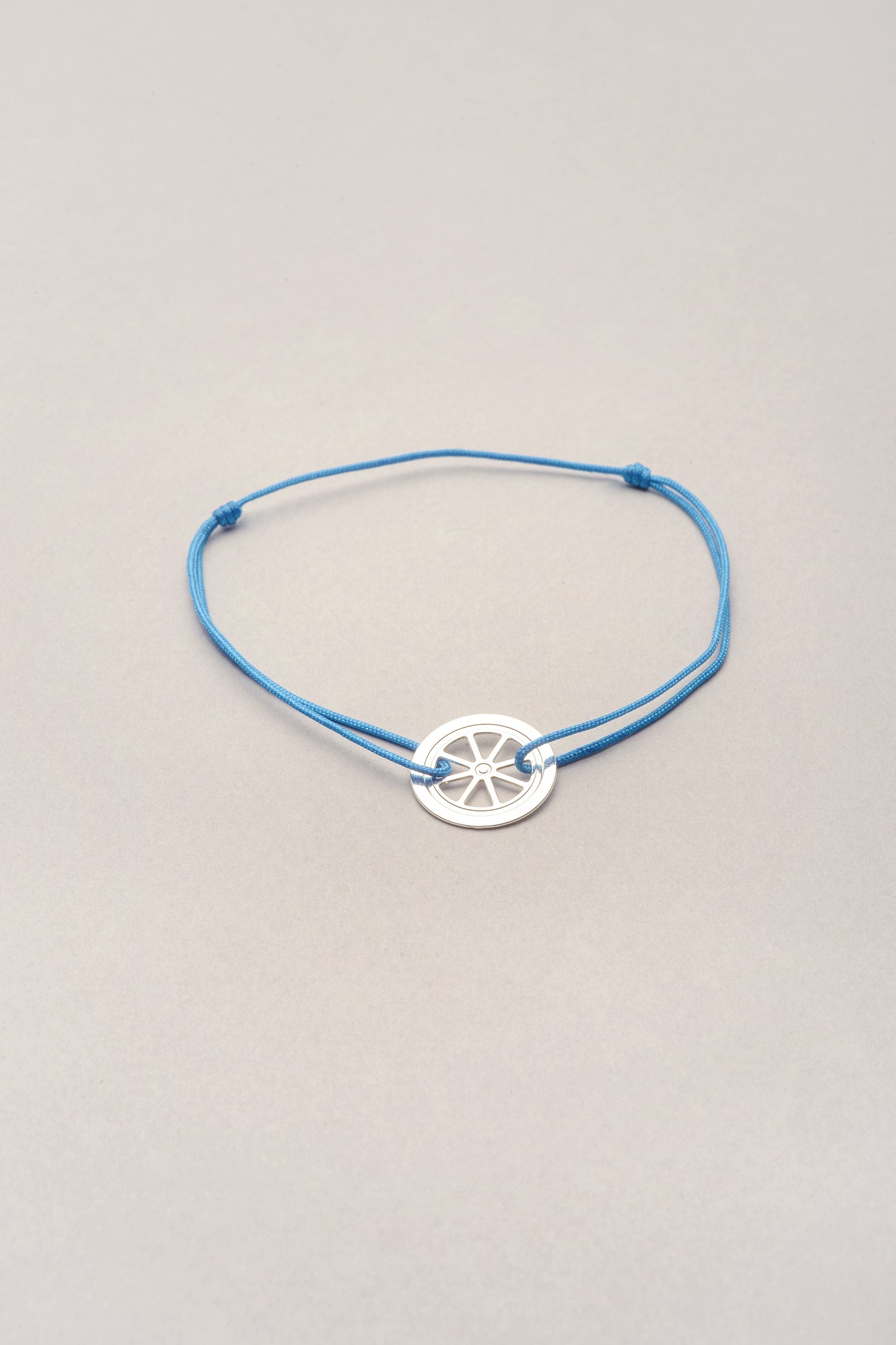 Bracelet mini roue argenté signature Musardise, bijou fantaisie made in France sur cordon coloré réglable avec pendentif roue gravée, assemblé à la main à Toulouse.