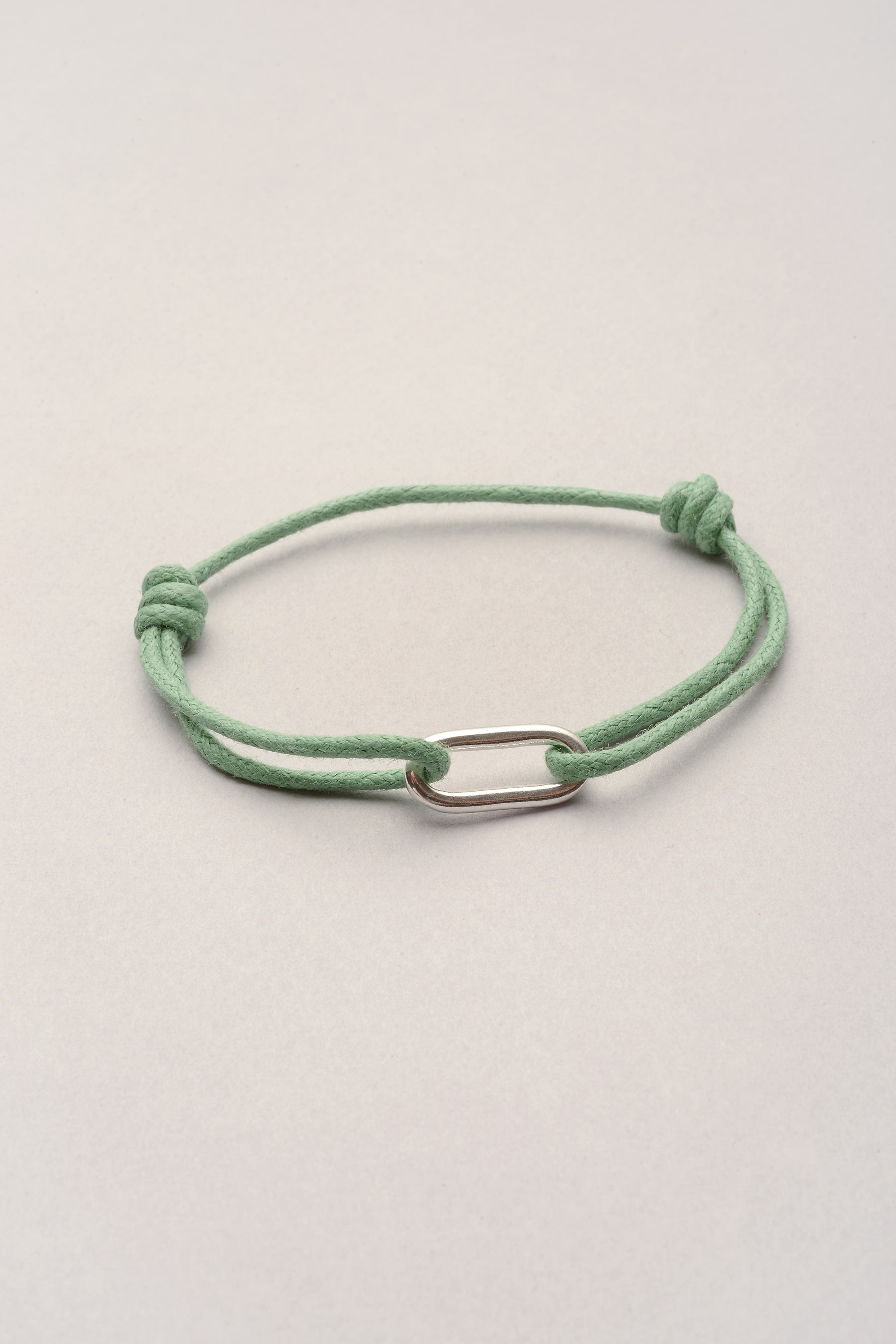 Ce bracelet est composé d'un pendentif oval allongé et d'un cordon de coton coloré. Ce bijou est mixte et conviendra parfaitement pour homme et femme. C'est un cadeau de couple idéal ! 