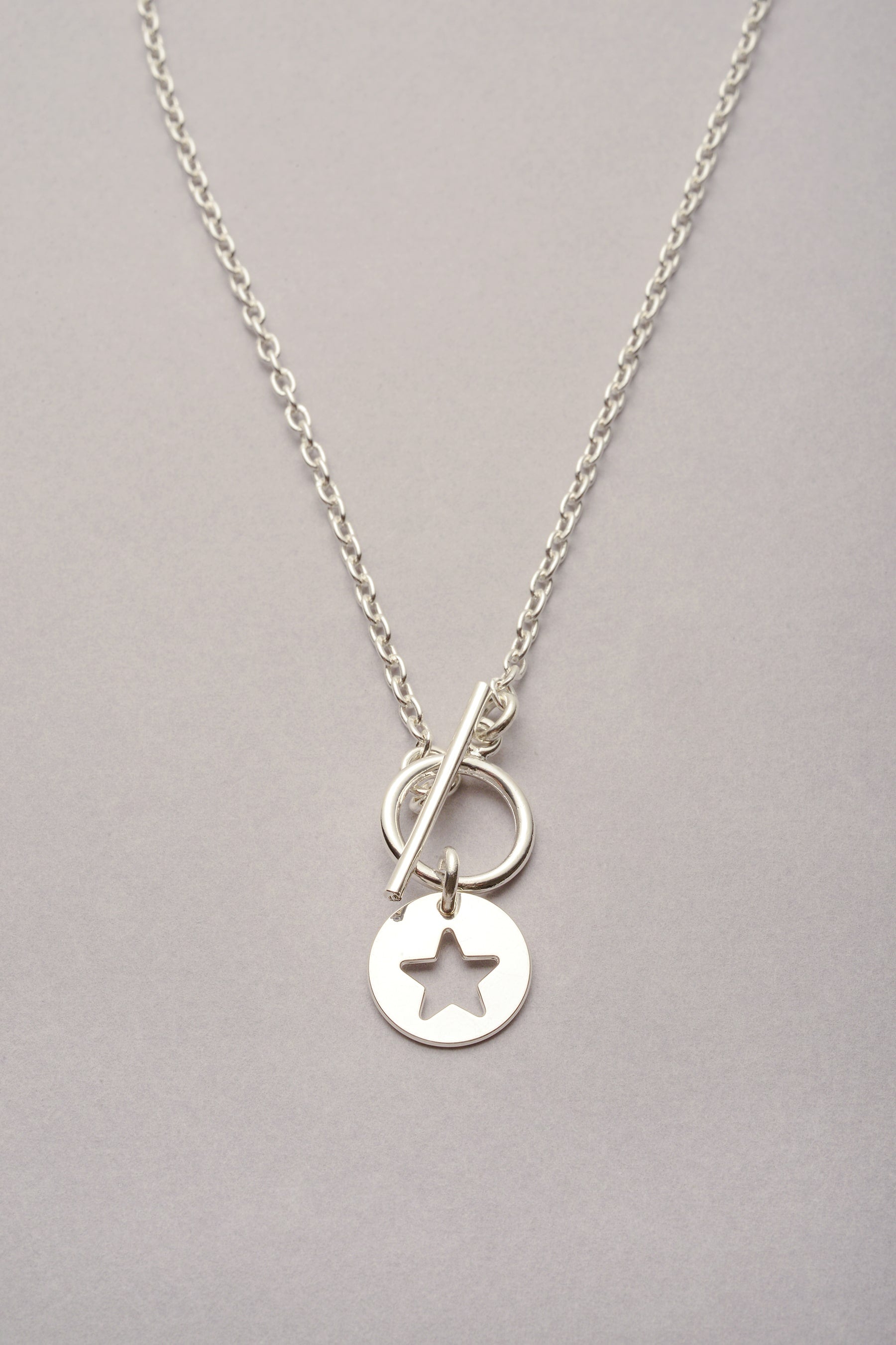 Le collier chaîne fine médaille étoile argenté "Lou" est fabriqué en France. Bijou pour femme avec fermoir en T et pendentif en forme de médaille. Best seller, ce collier convient à toutes les générations. Idée de cadeau pour femme, enfant et ado. Ce collier existe aussi en doré ! 