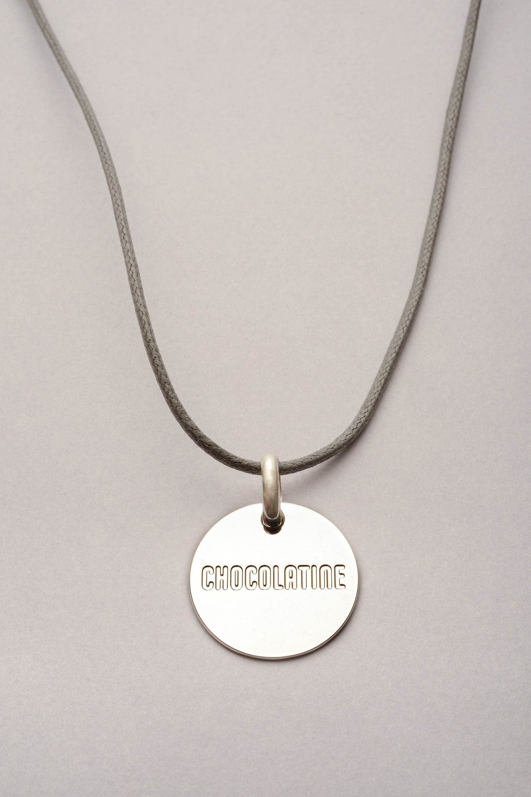 Ce collier est composé d'un cordon coloré réglable et d'une médaille sur laquelle est inscrite "chocolatine". Ce collier est fabriqué en France. 