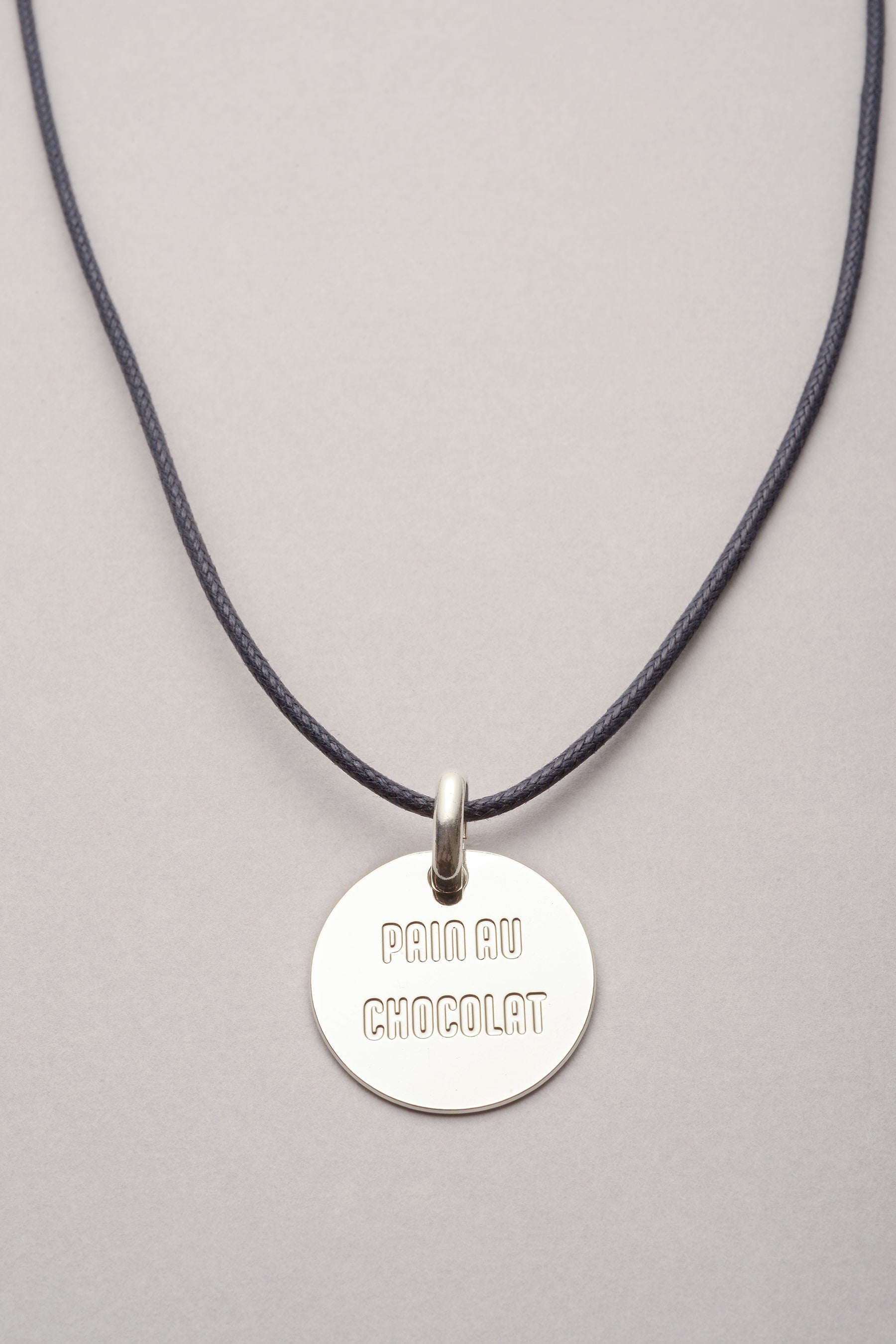 Ce collier est composé d'un cordon sur lequel une médaille est présente. Sur la médaille, le mot "Pain au chocolat" est gravé pour rappeler la célèbre bataille eavec la chocolatine du sud ouest. 