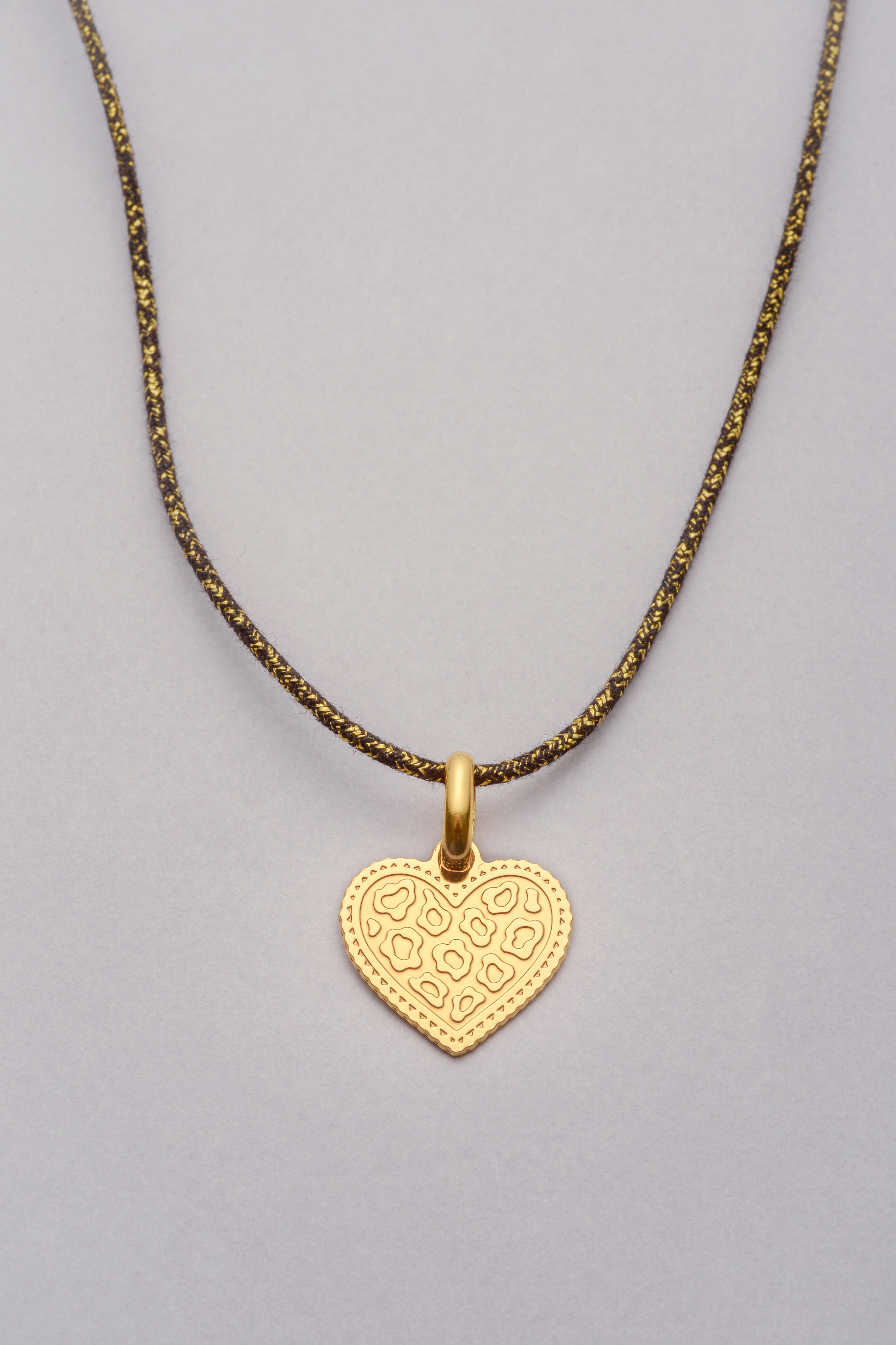 Collier doré avec pendentif cœur motif léopard, monté sur un cordon coloré réglable, photographié sur fond neutre.