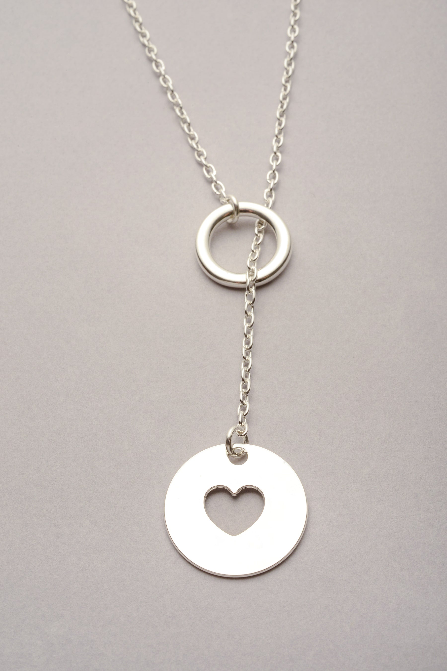 Collier sautoir argenté Daya avec pendentif rond cœur ajouré, bijou fantaisie élégant fabriqué en France.