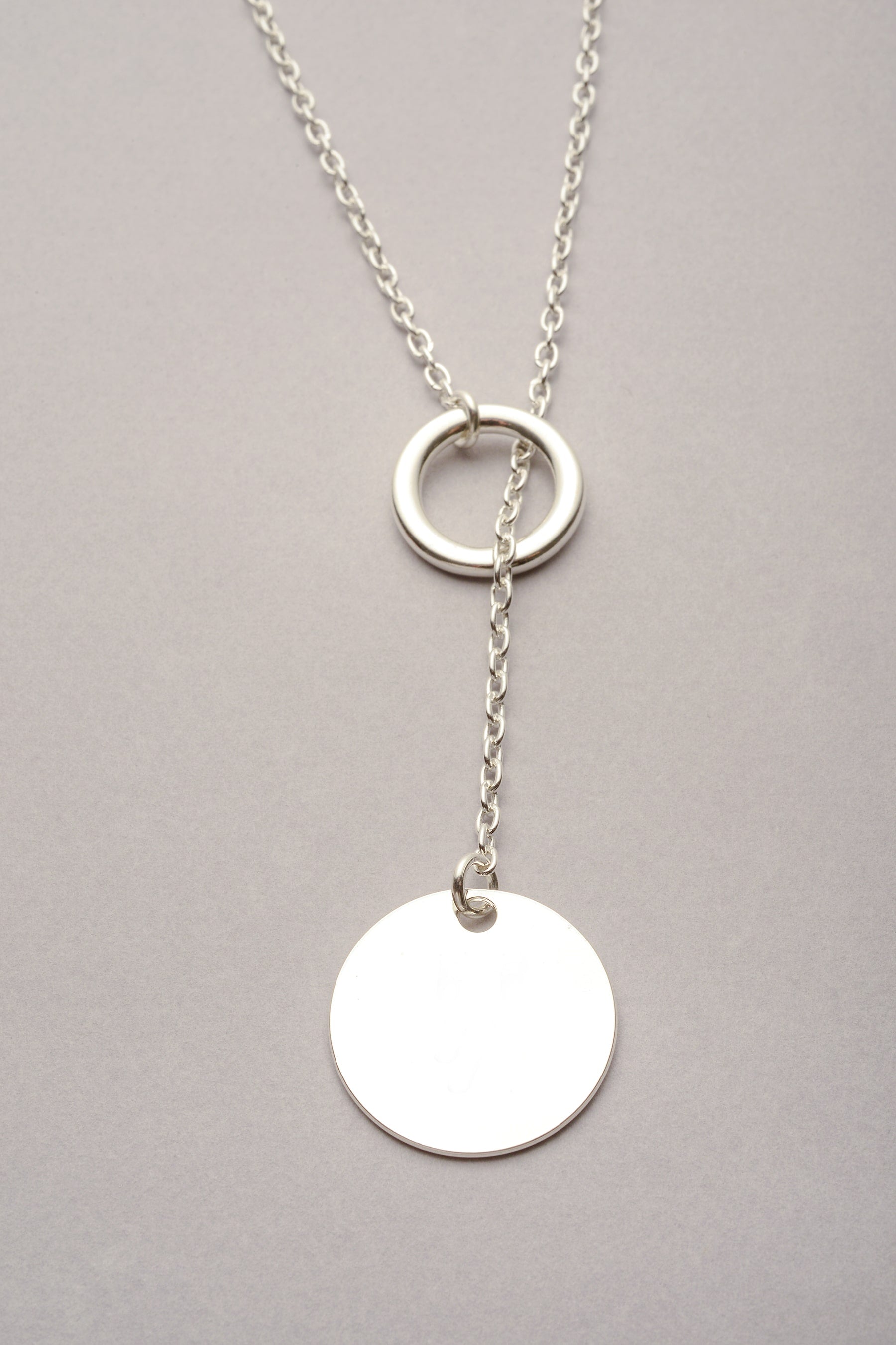 Collier sautoir argenté Daya avec pendentif médaille ronde lisse, bijou fantaisie moderne de chez Musardise et fabriqué en France.