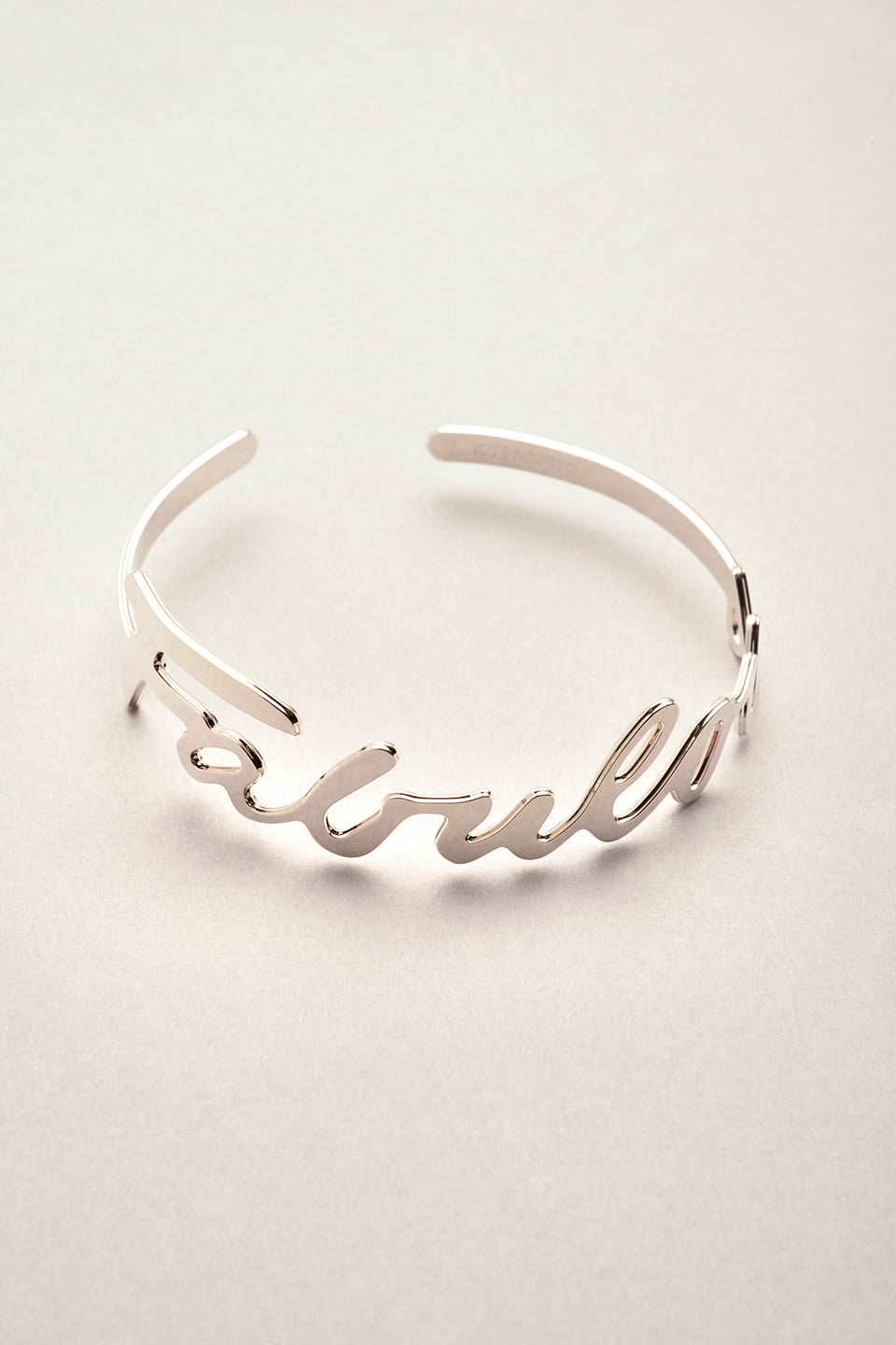 Ce bracelet jonc argenté est entièrement fabriqué en France. Le bijou s'ajuste au poignet, et on peut lire FABULOUS dessus. 
