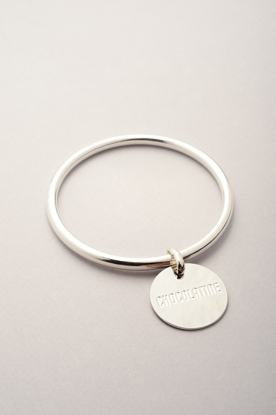 Bracelet jonc argenté avec médaille sur laquelle est gravée Chocolatine. Ce bijou fabriqué en France existe aussi en version pain au chocolat. 