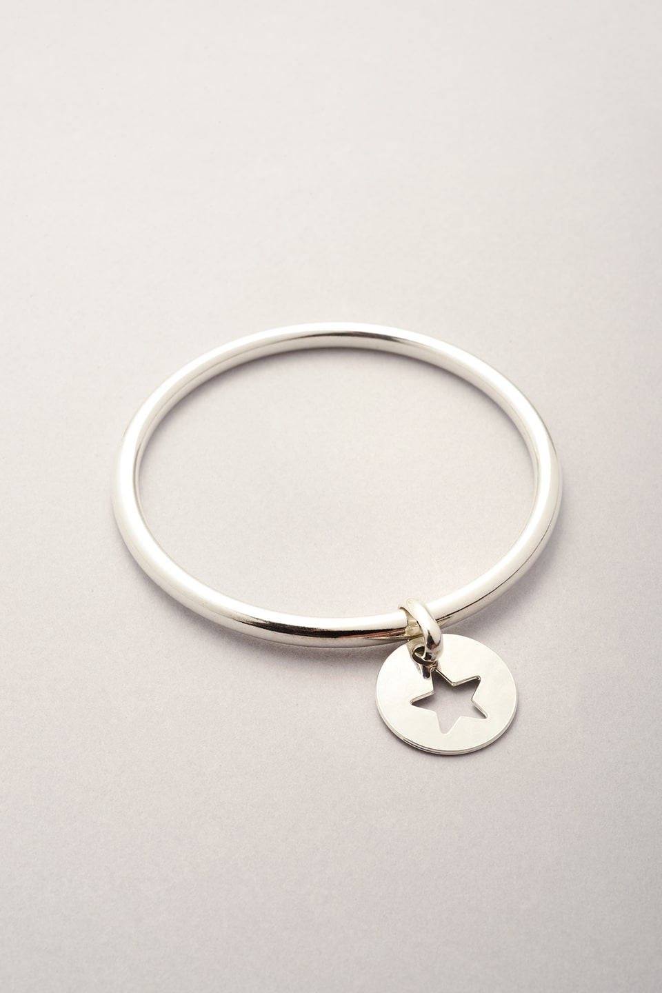 Ce bracelet jonc argenté est composé d'un pendentif médaille étoile évidé. Bijou pour femme argenté fabriqué en France. Cadeau pour enfant et femme. 