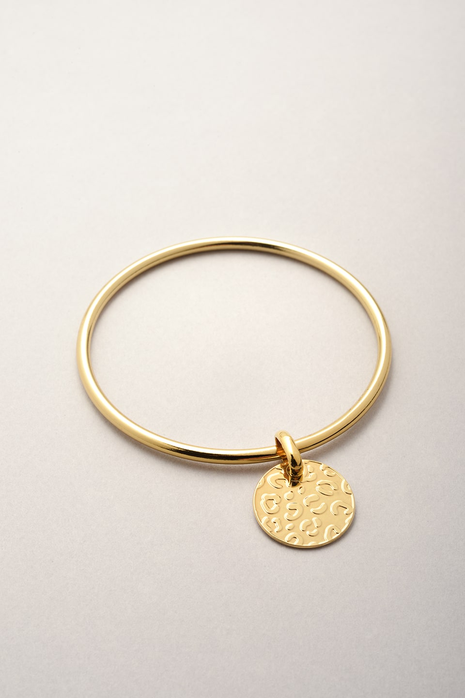 Ce jonc doré est composé d'une médaille avec des reliefs léopard. Bijou fabriqué en France pour femme. 