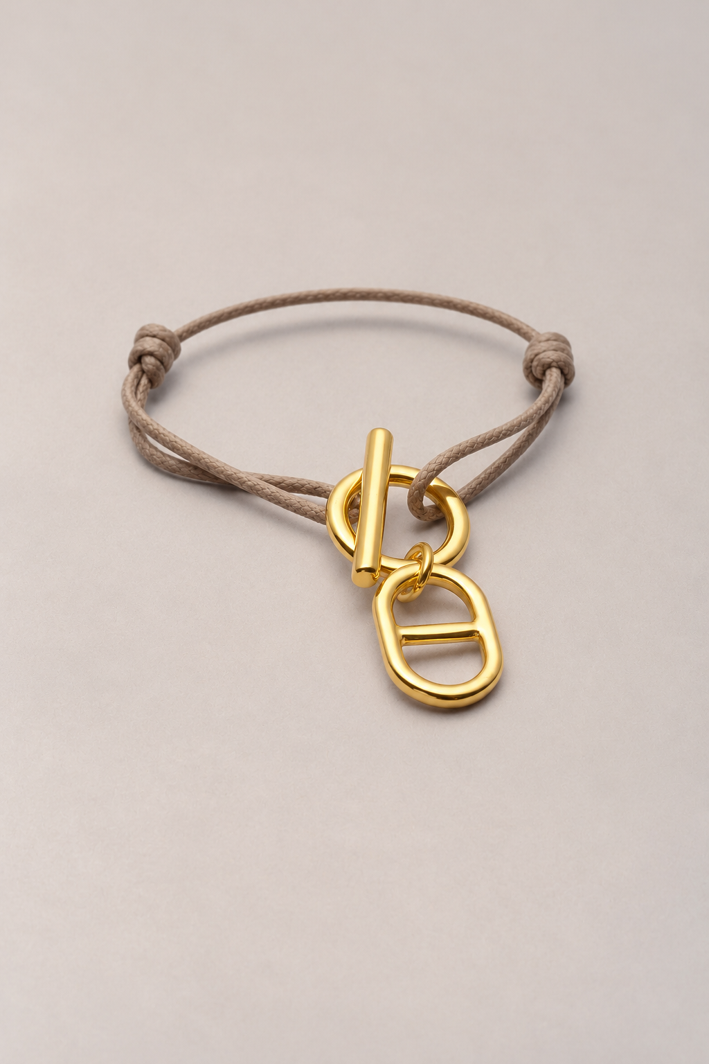 Bracelet attache maille doré Musardise sur cordon taupe ajustable, avec fermoir en T