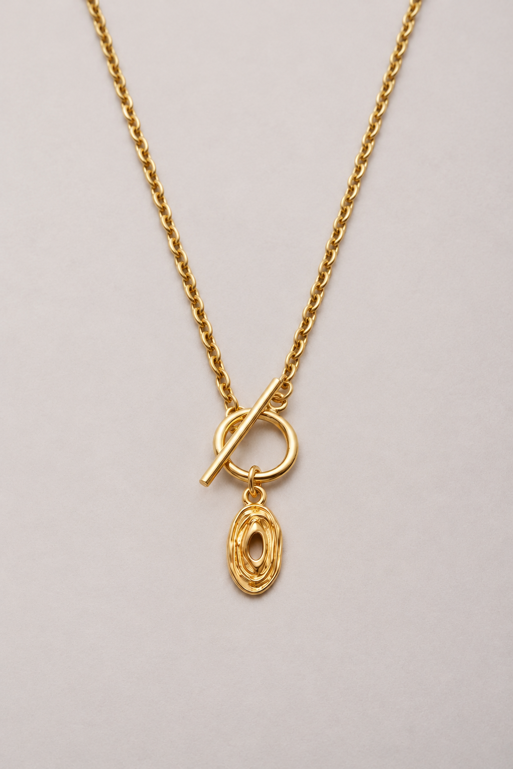 Collier Lou chaîne Hazel doré, pendentif ovale ajouré et fermoir en T