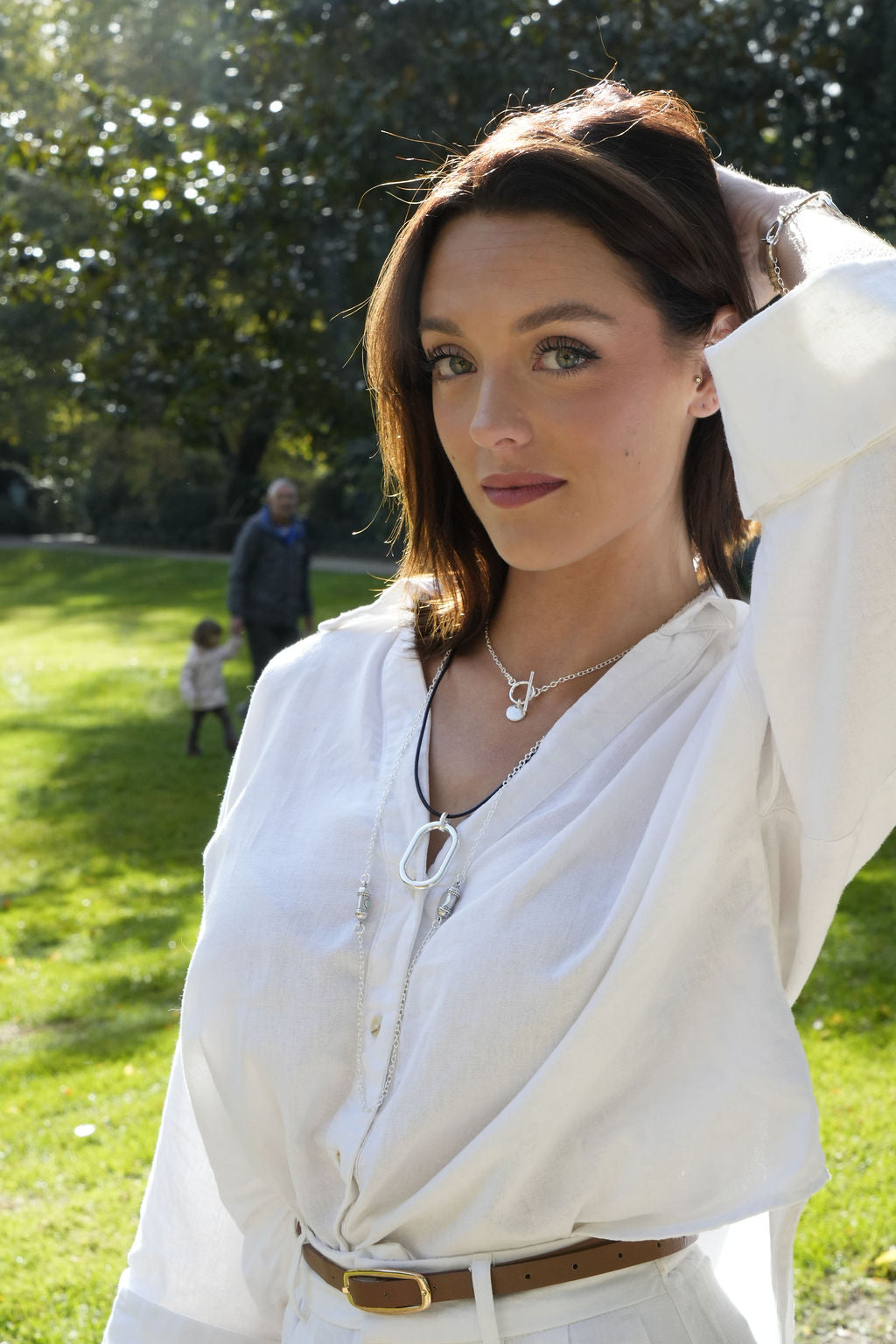 Collier Riviera argenté porté sur chemise blanche